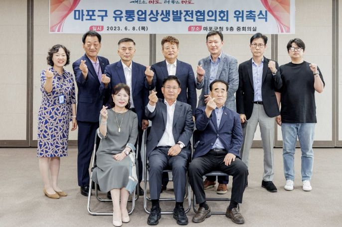 구청 중회의실에서 박강수 구청장과 마포구 유통업상생발전협의회 위원들이 위촉식을 마치고 사진을 찍고 있다.