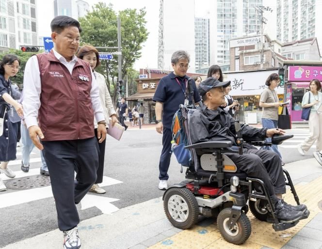 박강수 마포구청장이 휠체어를 탄 주민과 함께 새로 조성된 무장애길을 걷고 있다.
