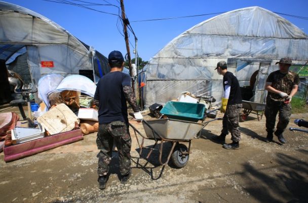 집중호우로 인한 피해를 입은 과천 화훼농가 복구를 위해 지난 11일 군부대 장병들이 수해 피해 현장에서 구슬땀을 흘리고 있다